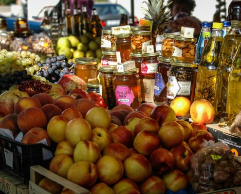 Marktstand mit Aepfeln, Honig, Oelen